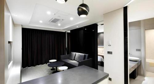 Una sala de estar con un sofá y una silla en una habitación. en Kintex by K-tree, en Isan