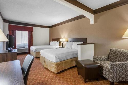 une chambre d'hôtel avec deux lits et une chaise dans l'établissement Best Western Tolleson Hotel, à Phoenix