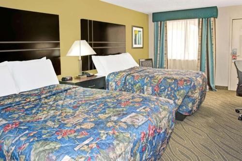 une chambre d'hôtel avec deux lits et une lampe dans l'établissement Howard Johnson by Wyndham Houston Heights/Downtown, à Houston