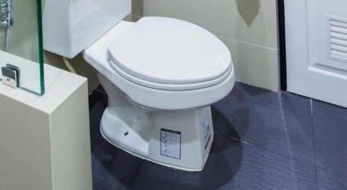 a bathroom with a white toilet in a room at Thanburi Hotel in Udon Thani