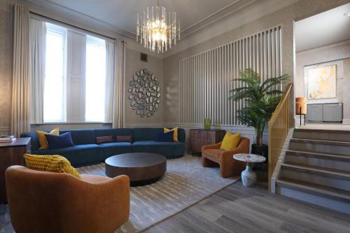 a living room with a blue couch and chairs at The Fort Garry Hotel, Spa and Conference Centre, an Ascend Collection Hotel in Winnipeg