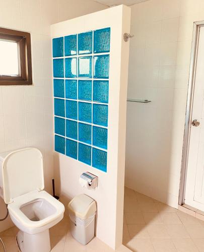 a bathroom with a toilet and blue tile on the wall at The1 Mangosteen Harmony Retreat - Khaolak - Eco Luxury Villa - Room Only -No Breakfast in Khao Lak