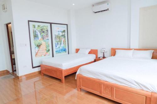 a bedroom with two beds and a painting on the wall at Luxury Airport Hotel & Spa in Phu Lo Dong