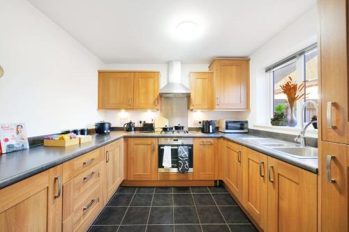 a kitchen with wooden cabinets and a sink at 3Bedroom 5Bed 2Bath Ensuite Prv-Parkin x2 in Amersham