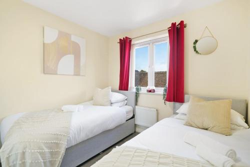 2 letti in una camera con tende rosse di 3 BR 5 Beds 3 Bath Private Garden Parking x2 Ideal for Family & Work Stays ad Amersham
