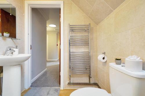 a bathroom with a toilet and a sink at King Size beds, CCTV parking , Discounts in Shinfield
