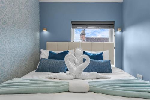 a bedroom with a bed with two swans on it at 2 King or 4 Single Beds Workspace Walk to Bedford Station Parking Wi-Fi in Bedford