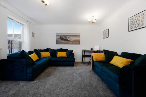 a living room with two blue couches and a table at 3 BR 6 Beds 3 Bath Garden Parking Heathrow 15 min Windsor & Legoland in Langley Marish