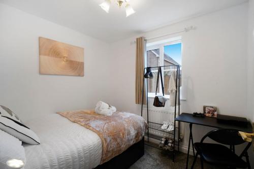 a bedroom with a bed and a desk and a window at 3 BR 6 Beds 3 Bath Garden Parking Heathrow 15 min Windsor & Legoland in Langley Marish
