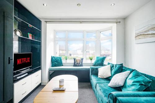 ein Wohnzimmer mit einem blauen Sofa und einem Fenster in der Unterkunft Prv-Parking Jacuzzi Bath Families Groups in Elstree