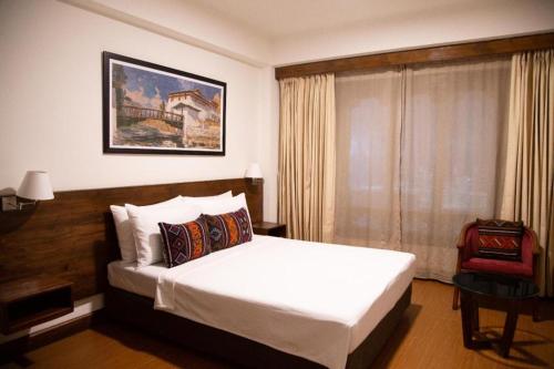 a bedroom with a white bed and a window at Lemon Tree Hotel Thimphu in Thimphu