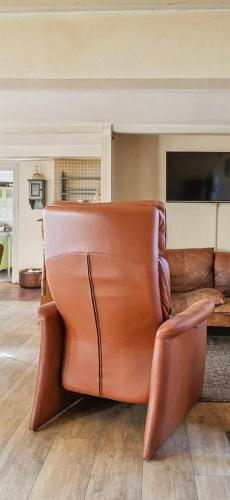a brown leather couch sitting in a living room at Syrenhuset in Veflinge