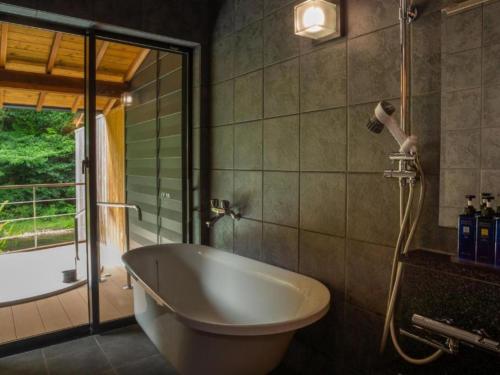 a bath tub in a bathroom with a window at Tsukiyominoza in Ise