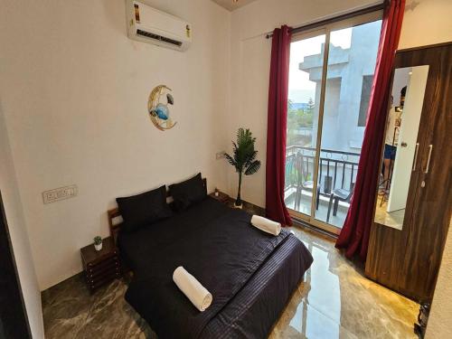a bedroom with a black bed with a large window at Ventara Bliss Bungalow by Palette Homes ? 4 BHK | Pvt Pool | Lonavala in Kārli
