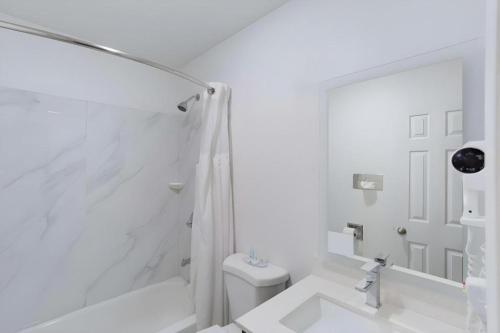 een witte badkamer met toilet en douche bij Quality Inn Redding near I-5 in Redding