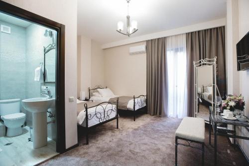 a bathroom with two beds and a sink in a room at Golden Nugget Tbilisi in Tbilisi City