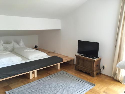 a bedroom with a bed and a flat screen tv at Seehaus Familie Leifer in St. Wolfgang