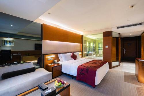 a hotel room with a bed and a couch at Grand View Hotel Tianjin in Tianjin