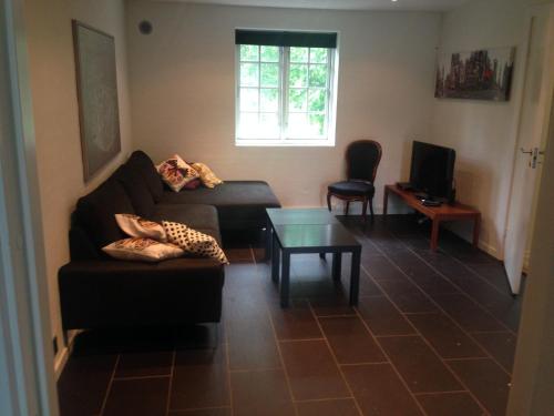 a living room with a couch and a table at Rane Ladegaard in Ebeltoft