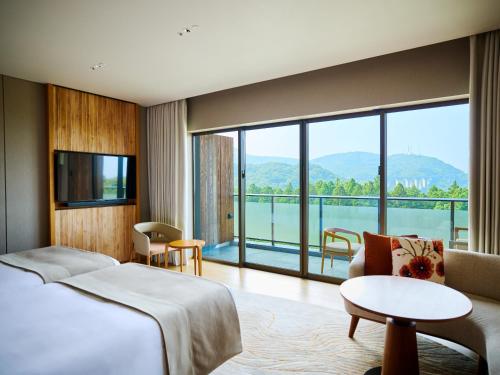 une chambre d'hôtel avec un lit et une grande fenêtre dans l'établissement ANA InterContinental Beppu Resort & Spa by IHG, à Beppu