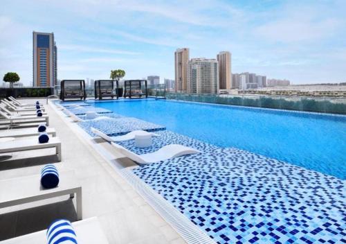 a large swimming pool on the roof of a building at Luxery Hotel Apartment l Novotel Residence l JVT in Dubai