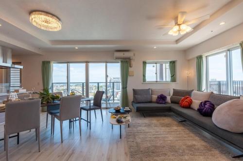 a living room with a couch and a table at エンズプラザライカム1201 in Okinawa City