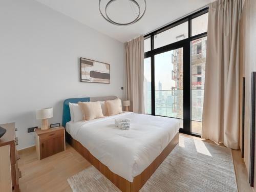 a bedroom with a bed and a large window at Vista Grande Luxury 3br In Reem By Ayla in Abu Dhabi