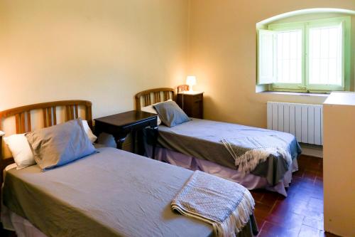 a room with two beds and a window at Can Guilla Gaudeix in Corro d'Amunt