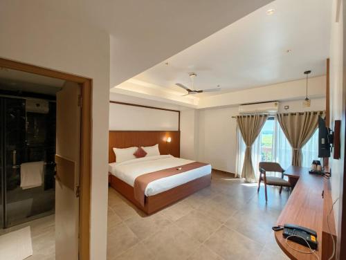 Un dormitorio con una cama, un escritorio y una mesa. en Hotel Srimanta sankardev, en Majuli