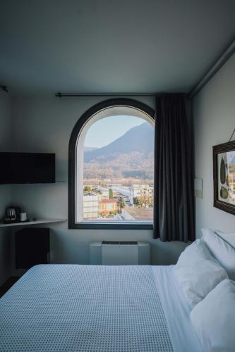 a bedroom with a large window and a bed at La Ripa Boutique Hotel in Albino