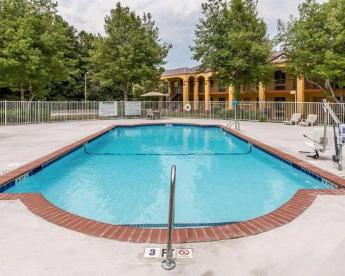una gran piscina de agua azul frente a una casa en Econo Lodge Dalton West, en Dalton