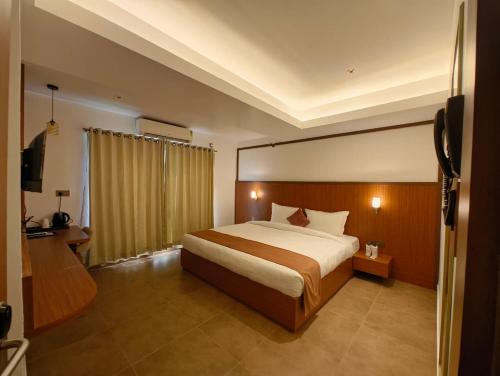 una habitación de hotel con una cama y un televisor en Hotel Srimanta sankardev, en Majuli