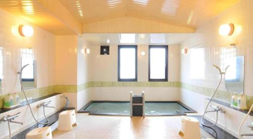 a large bathroom with a swimming pool in it at Espoir Misawa in Chikuni