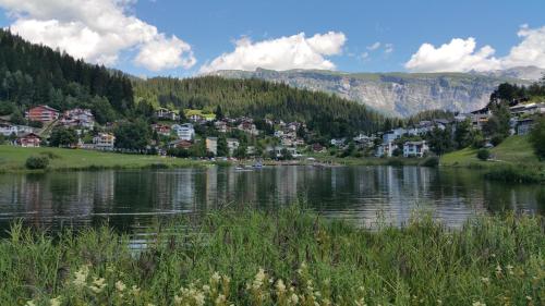 a lake in a valley with houses and mountains at Rancho Laaxdeluxe in Laax