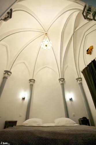 a bedroom with a bed with a white ceiling at Hotel Le Prieuré et La Résidence in Amiens