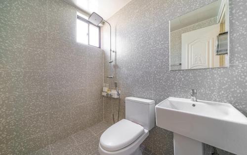 een badkamer met een toilet, een wastafel en een spiegel bij Tongyeong Daon Hotel in Tongyeong
