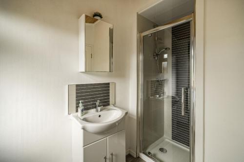 a white bathroom with a sink and a shower at Lakeview Lodge in Carnforth