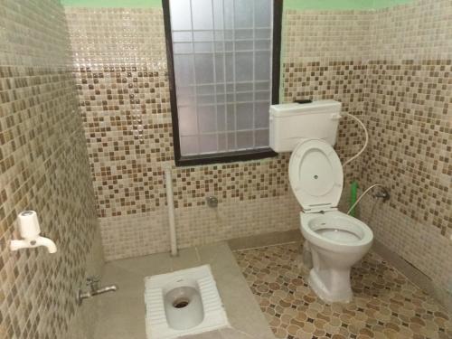 ein Bad mit einem WC, einem Fenster und einem Waschbecken in der Unterkunft Prince Home Stay in Jāmb