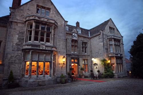 a large stone building with a clock on it at The Old Deanery - Restaurant With Rooms in Ripon