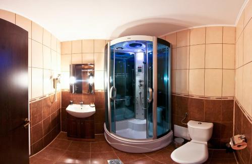 Un baño con ducha, inodoro y lavabo. en Pension Curmatura Stezii, en Răşinari