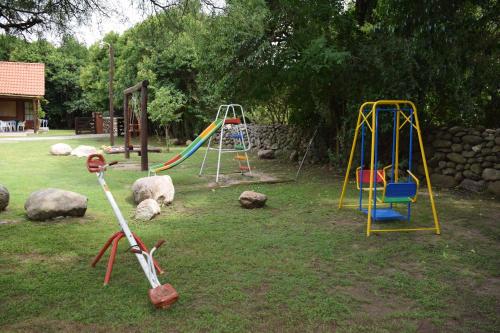 a playground with a swing set in a yard at Cabañas La Curucucha in Nono