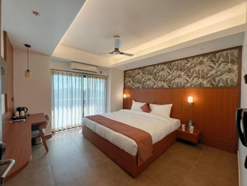 a bedroom with a large bed and a large window at Hotel Srimanta sankardev in Majuli