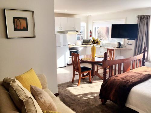 eine Küche und ein Wohnzimmer mit einem Tisch und einem Sofa in der Unterkunft Motel Mayfair on Cavell in Hobart