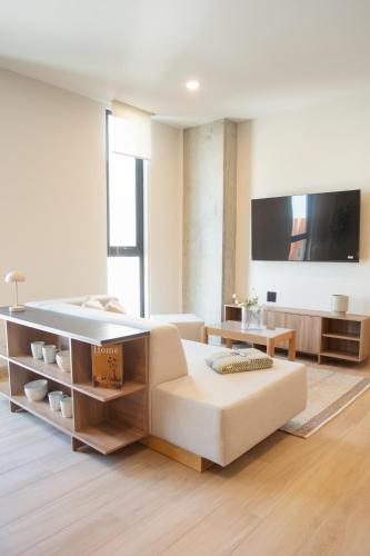 a living room with a couch and a tv at Margot Apartments By MrW in Guadalajara