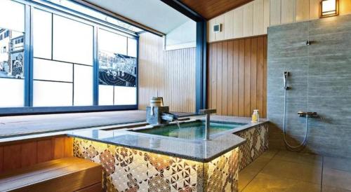 a large bathroom with a sink and a shower at Hotel Kogure in Shibukawa