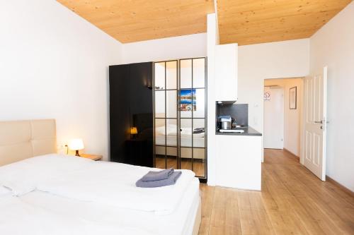 a bedroom with a white bed and a kitchen at 213 Prag, Studio Apartment, 27m2, 1-2 Personen in Klagenfurt