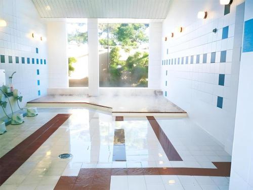 a large white room with a bench in the middle at Shirako New Seaside Hotel in Shirako