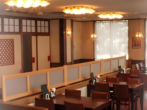 a dining room with tables and chairs and lights at Odate Green Hotel in Odate