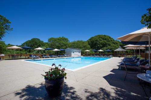 a swimming pool with tables and chairs and umbrellas at The Atlantic in Southampton