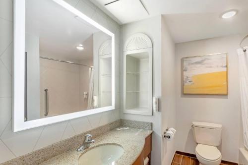 a bathroom with a sink and a toilet and a mirror at Comfort Suites East Brunswick - South River in East Brunswick